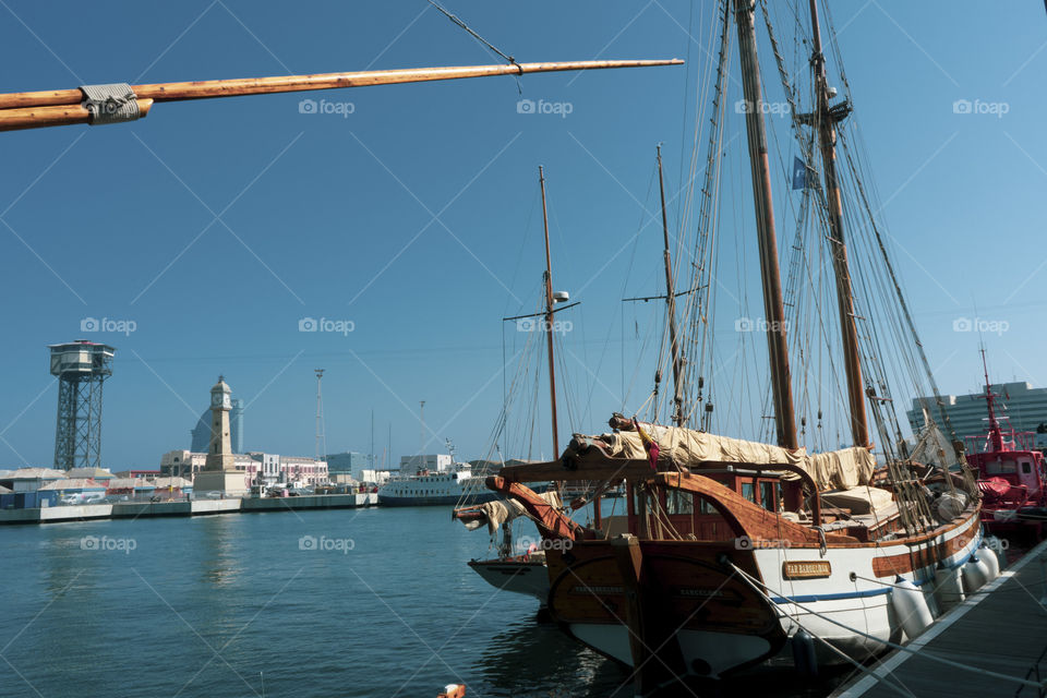 An ancient boat moored near the port of Barcelona. In the background you can see the cable car that leads to Montjuic.
