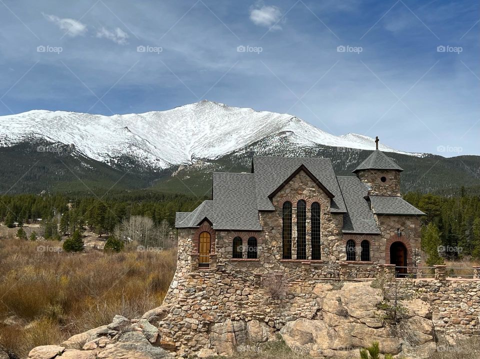 A quaint church surrounded by the Rocky Mountain Range