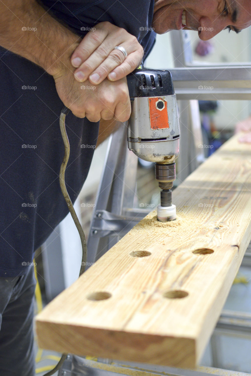 Man drilling hole in wood