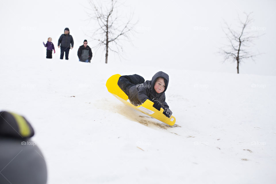 Boy sledding in winter 