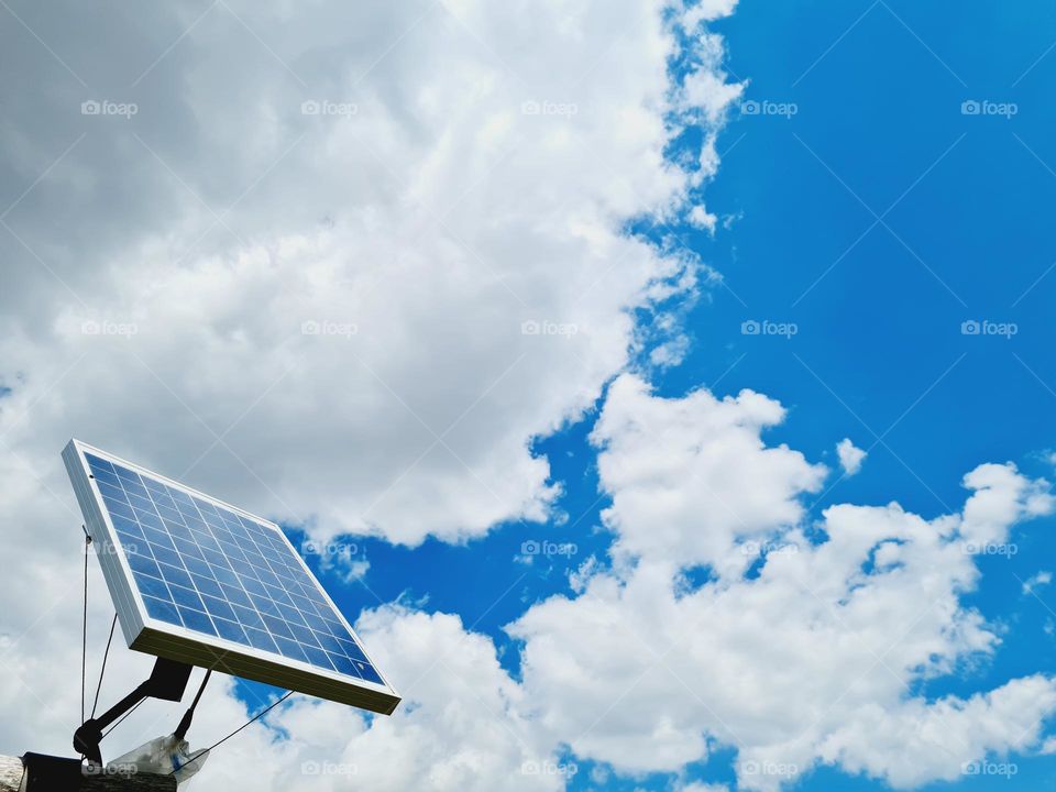 small photovoltaic panel powered by clean energy surrounded by sky and clouds