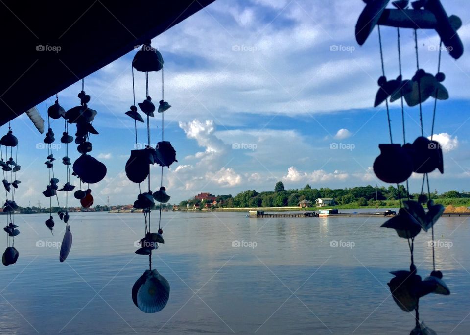 Hanging craft mobiles against River and blue sky background