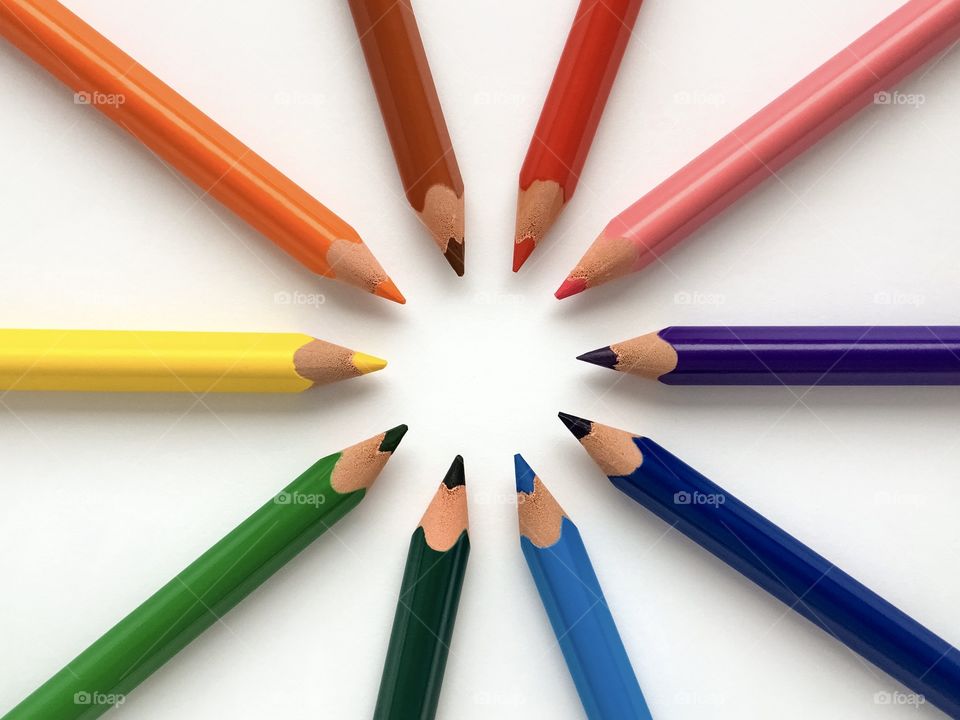 Colorful pencils on white table, circle