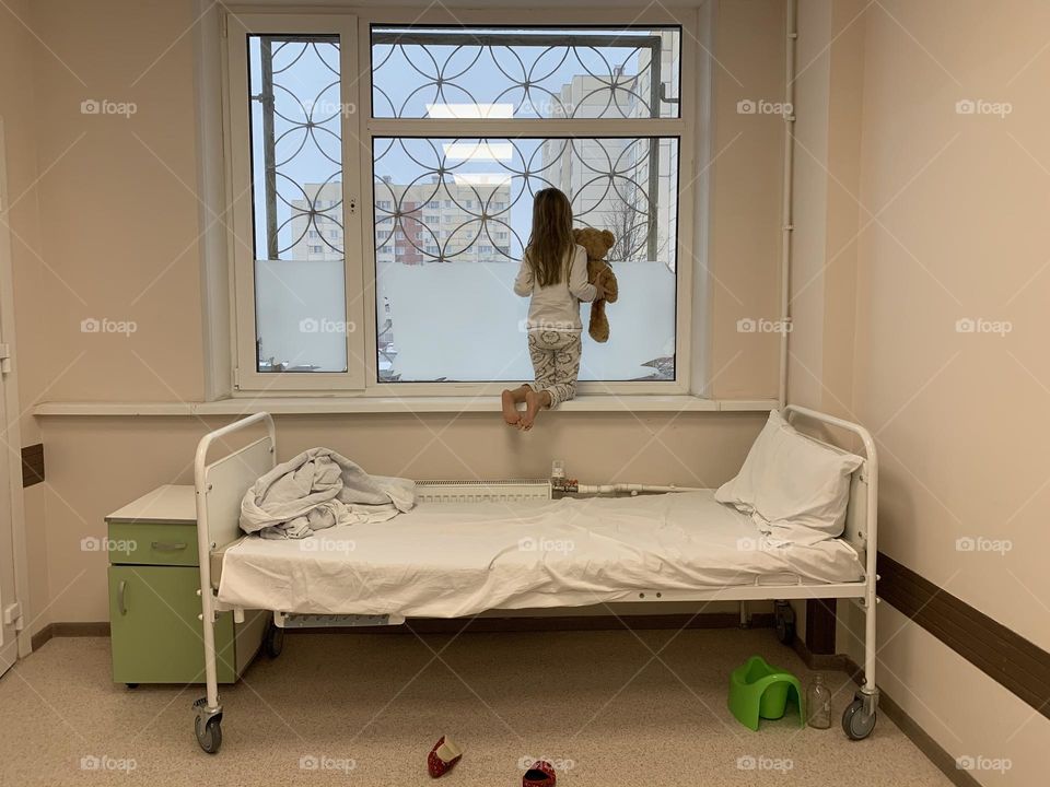 Kid at the hospital looking through the window 