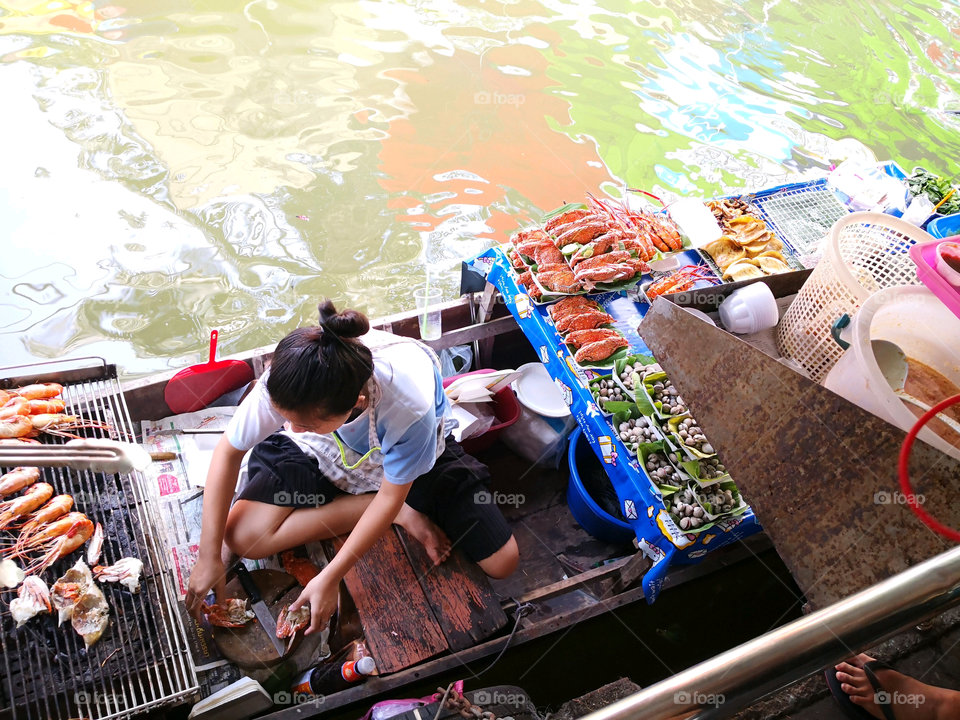Seafood vendor on a boat in Talingchan Floating Market in Bangkok