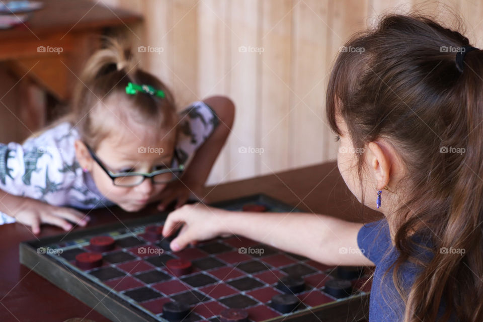 Two little girls playing checkers