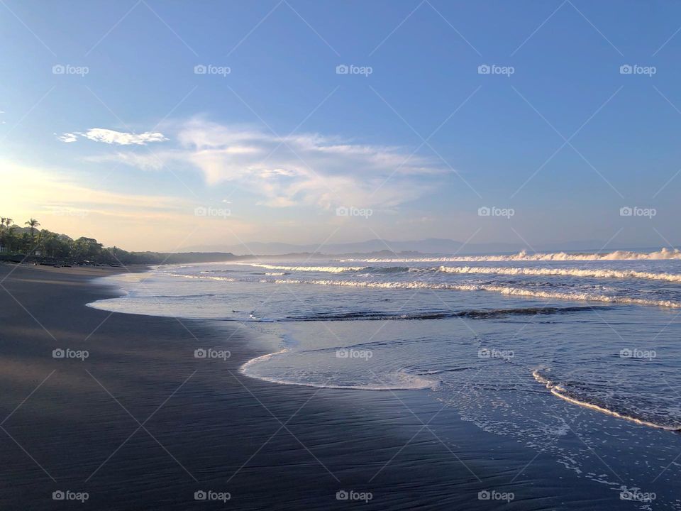 Early morning walk along private black sand beach in Costa Rica 