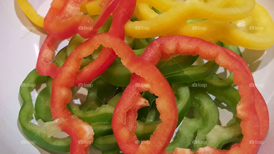 Colorful chopped peppers. Red, green and yellow chopped peppers on white background