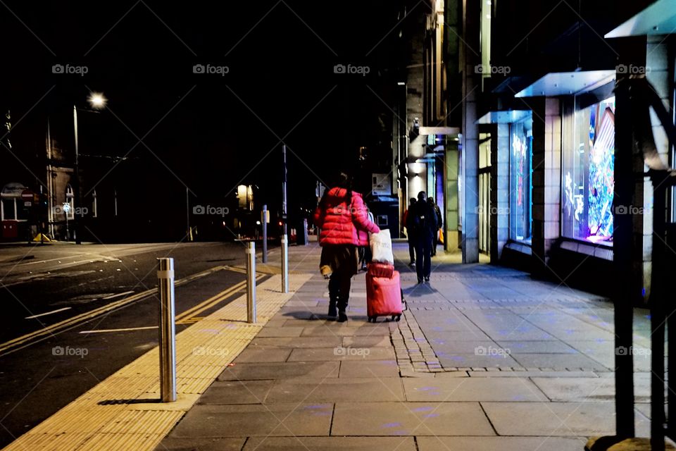 woman travelling on the road at night keeping suitcase