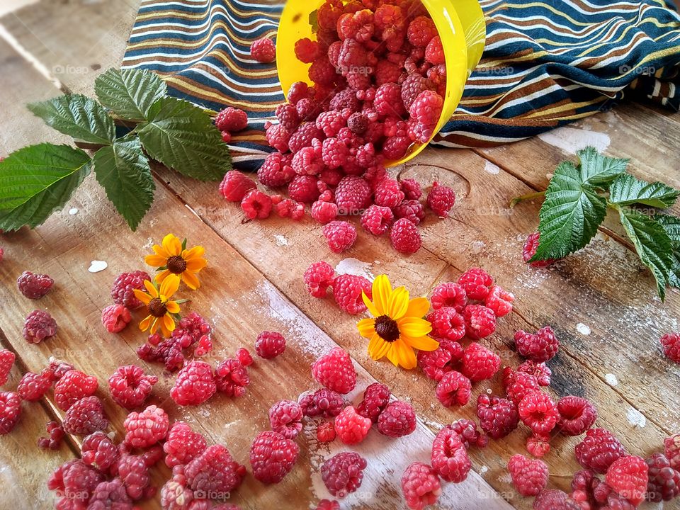 juicy berries of summer! raspberries in a yellow basket and small yellow flowers for a summer mood!