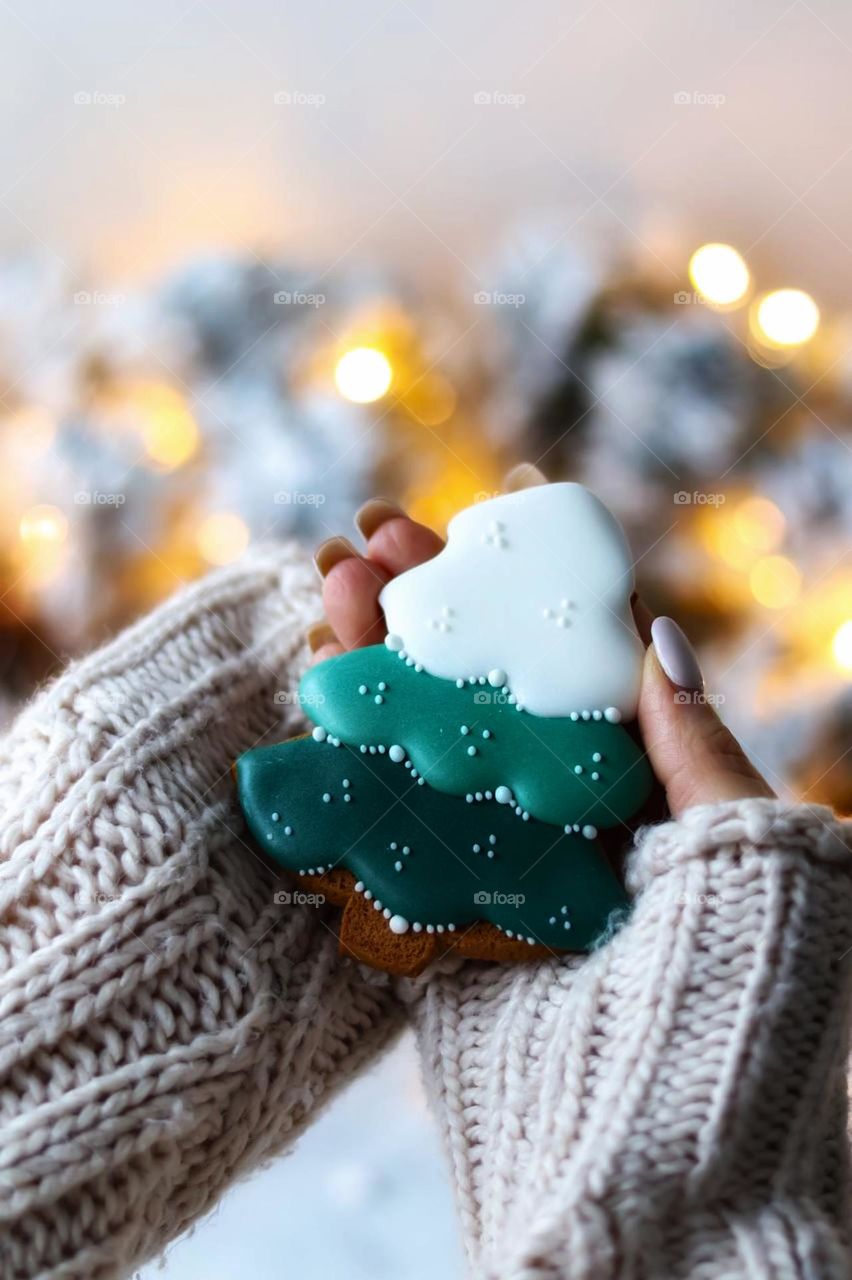New Year's baking. A woman holding a gingerbread gingerbread in the shape of a Christmas tree
