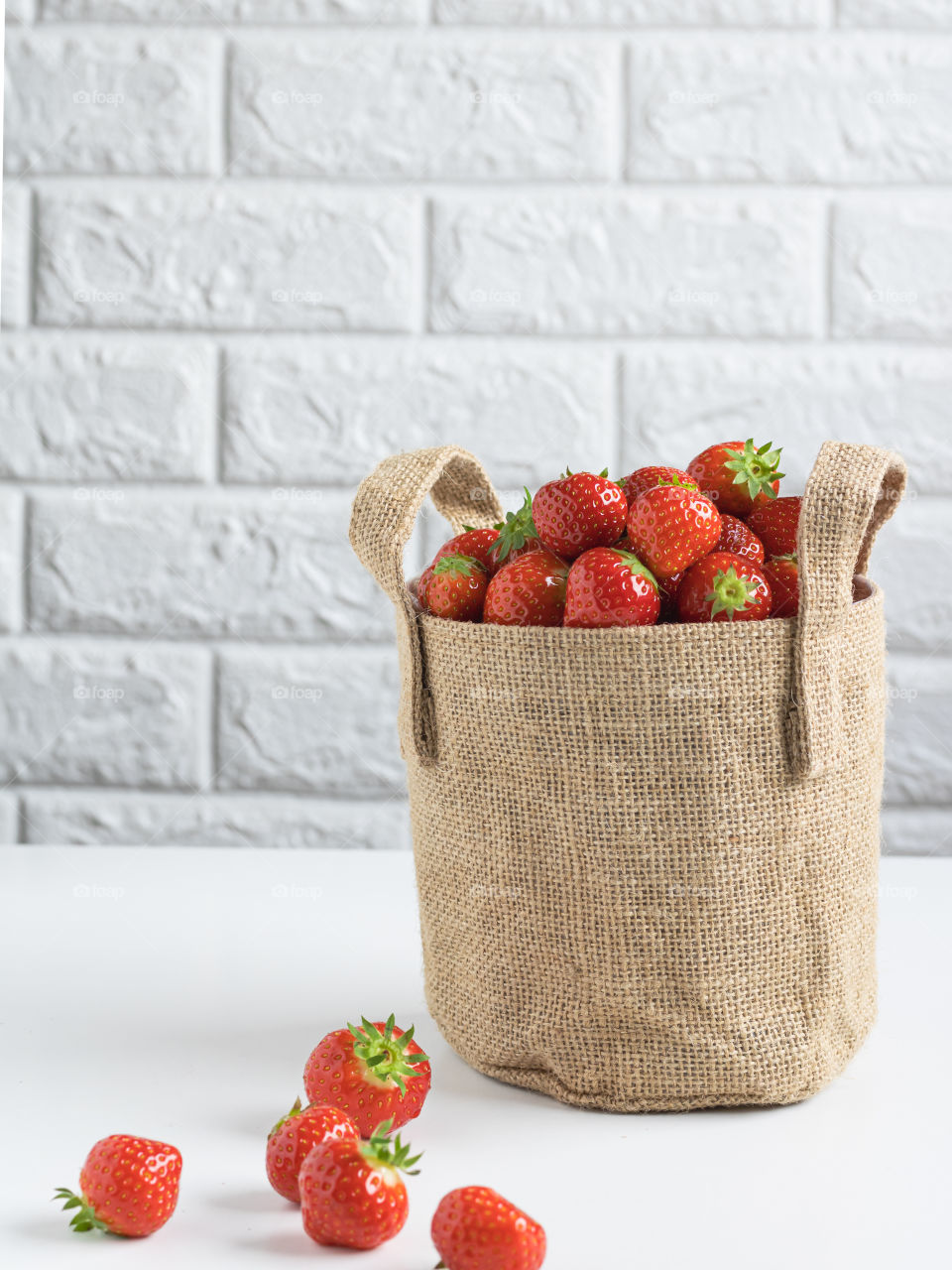 Jute bag full of ripe fresh strawberries 