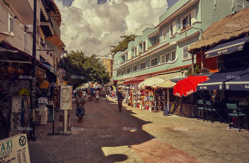 5th avenue of Playa del Carmen on a summer afternoon crowded with tourists strolling through the shops and stalls.
