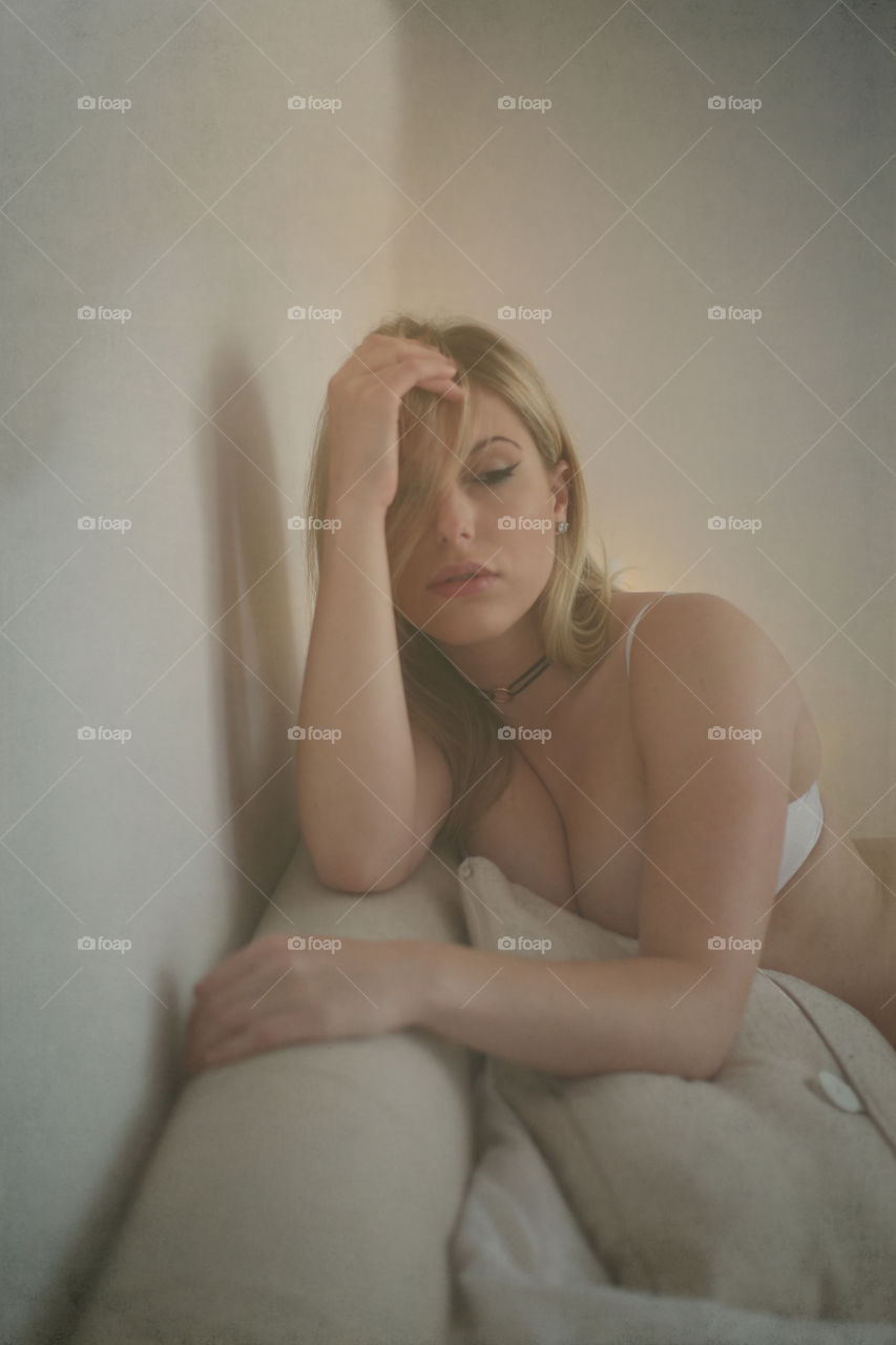 Depressed sensual woman sitting on sofa