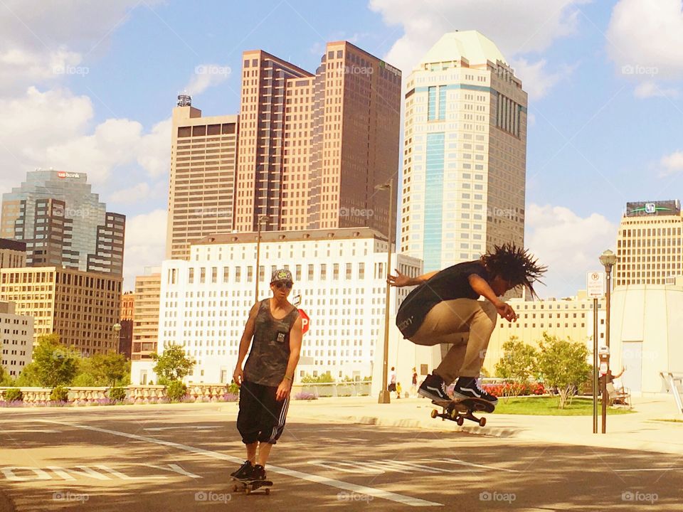 Skateboarders doing tricks in the city.