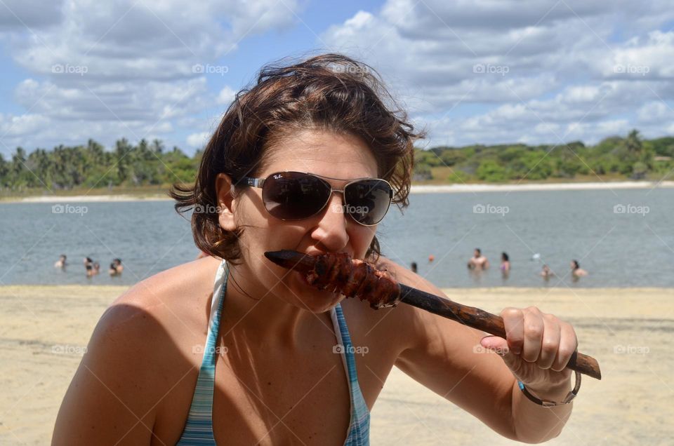 Woman eating in the beach 