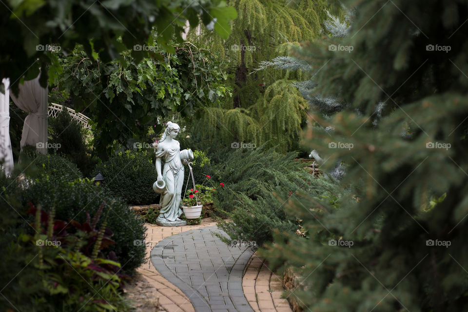 Road in the park to the white statue