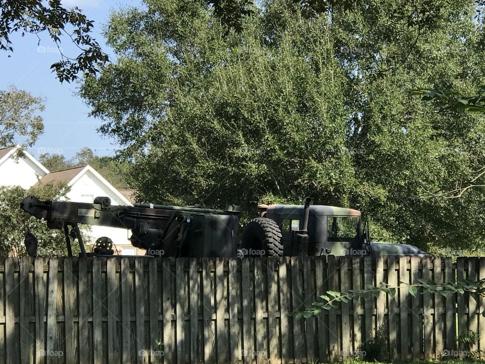 Military vehicle behind a wooden fence 