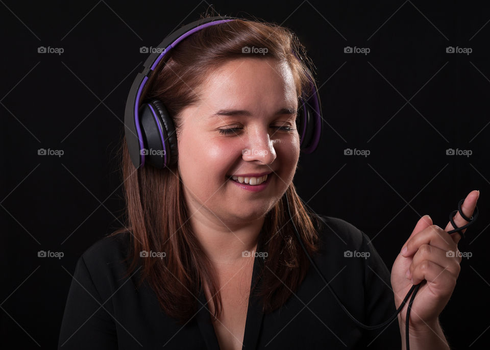 Happy young woman listening to music on headset.