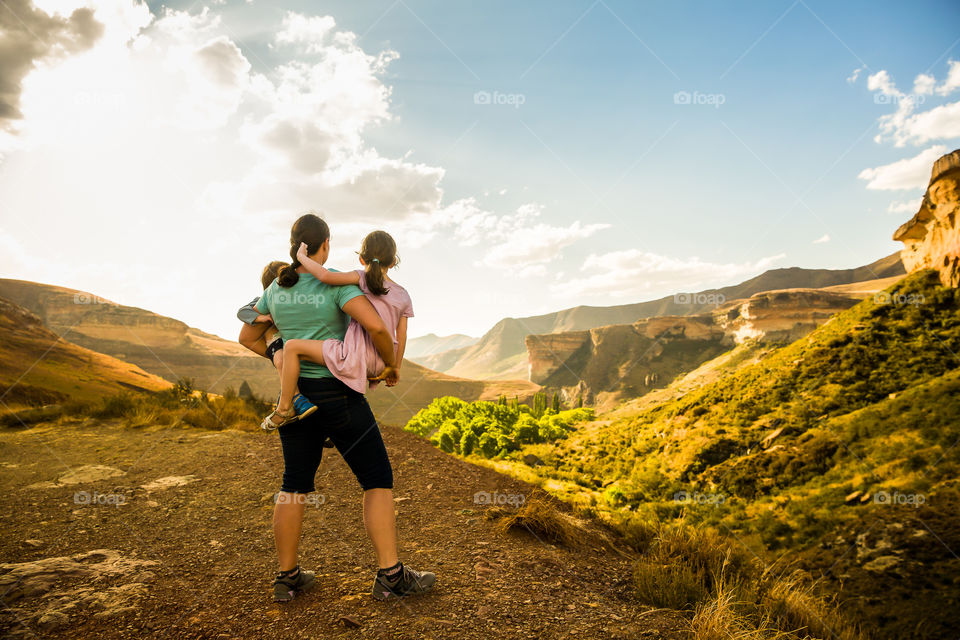 2019 my year of health. Image of mom holding her two children overlooking beautiful scenery at Golden Gate national park South Africa