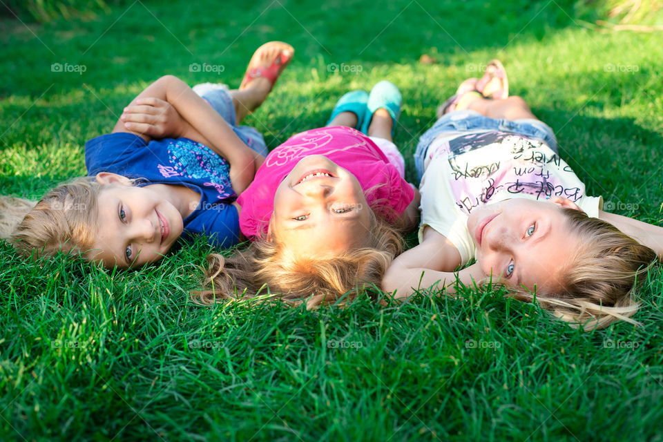 Three little girl lying on grass