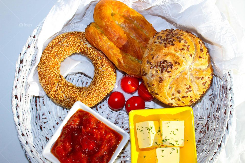 Traditional breakfast : rolled pie, pastry with seeds, butter and jam in a wicker basket