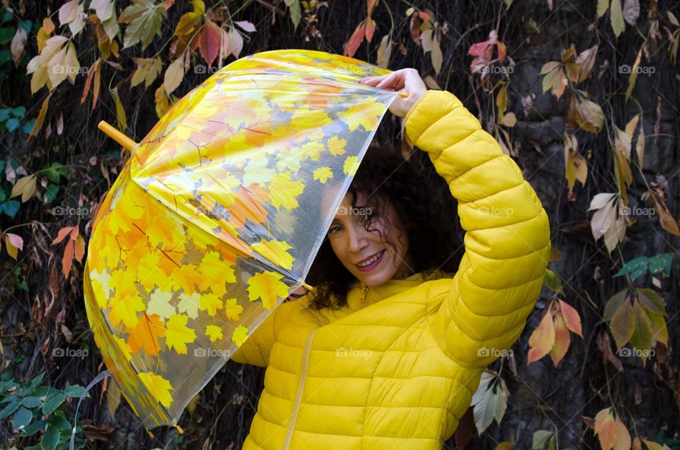 Smiling Woman with Umbrella on Autumn Background