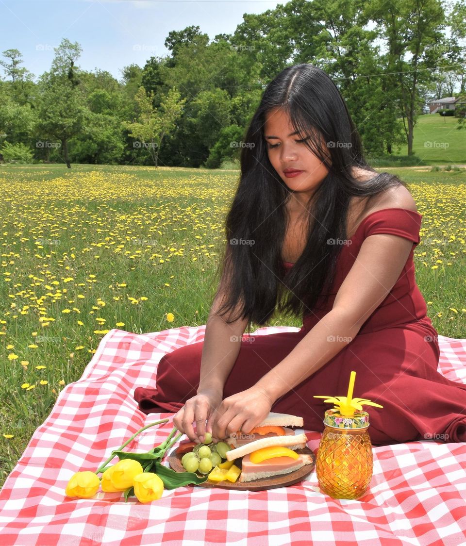 Girl enjoying picnic lunch on a beautiful spring day 