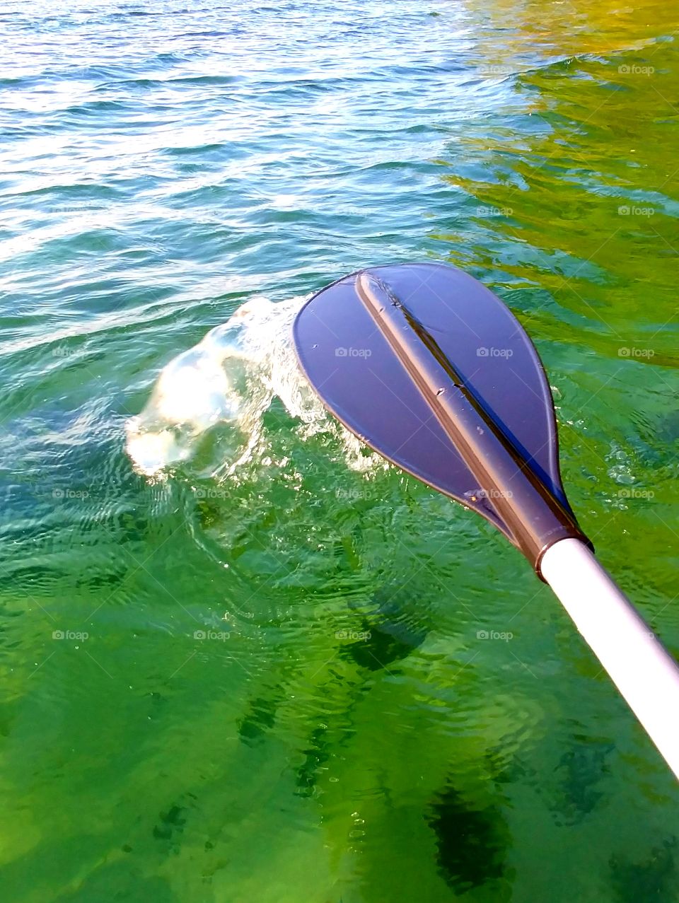 My oar kicks up the salty water.