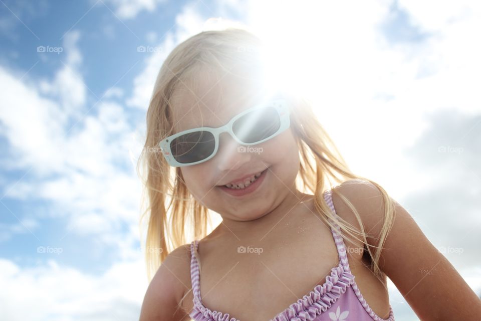 Little girl with sun behind her