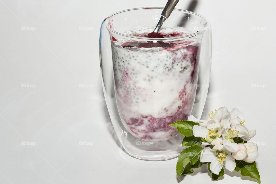 Delicious dessert of yogurt with chia seeds and cherry jam decorated with cherry blossom