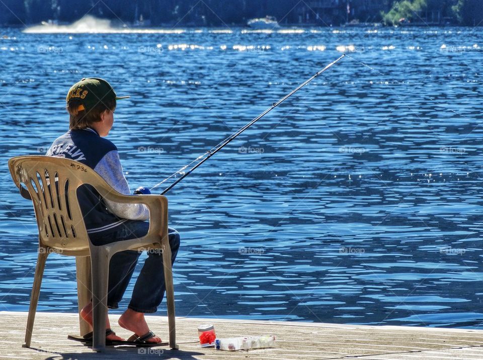 Young Boy Waiting Patiently To Catch A Fish. Boy Fishing On A Lake