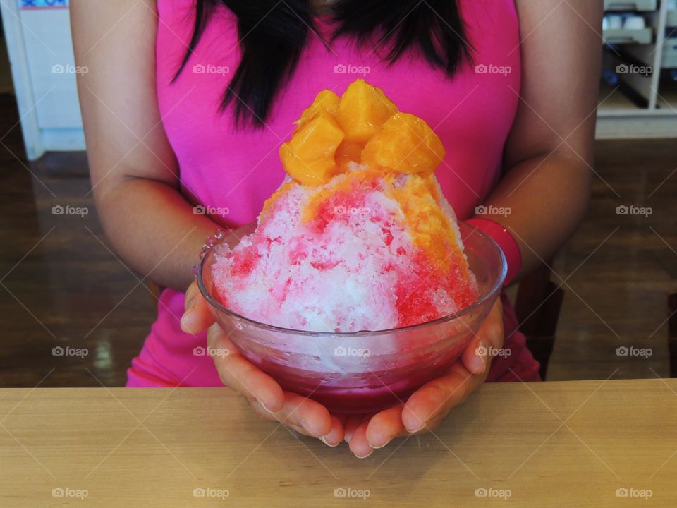 A woman hand holding bowl of frozen sweet food