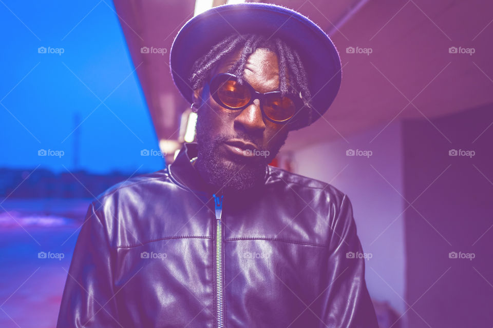 black handsome and stylish young man posing by night in the city - street fashion, black lives matter