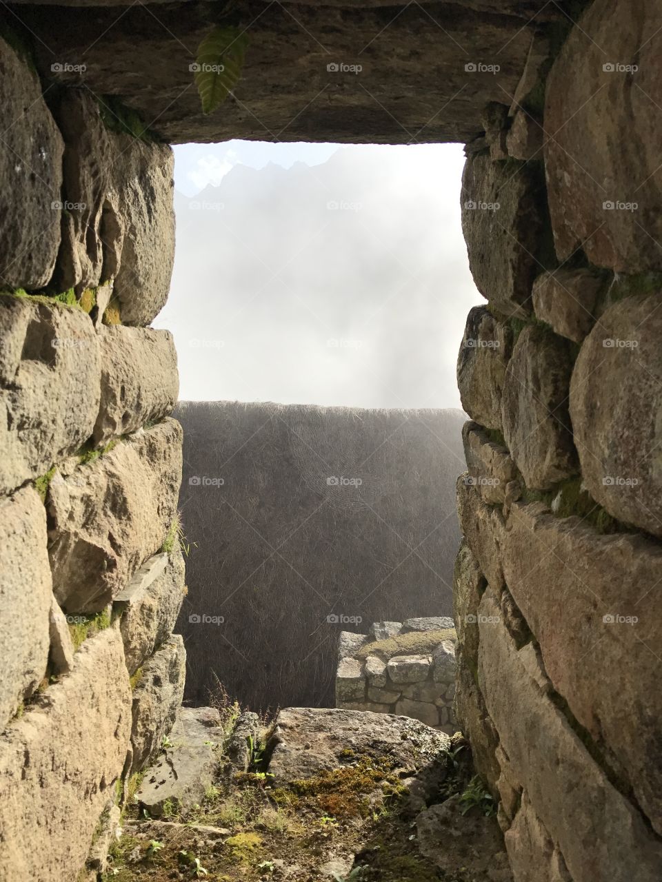 Fog blurs the sight of the mountain through the Wind Gate along the Moonstone Trek in Peru. 