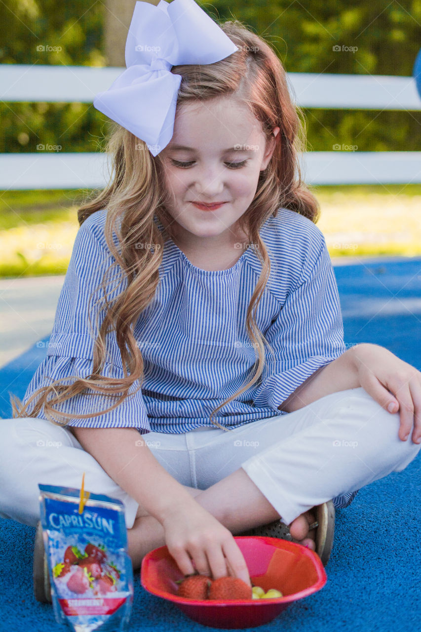 Young Girl Eating Fruit at the Park