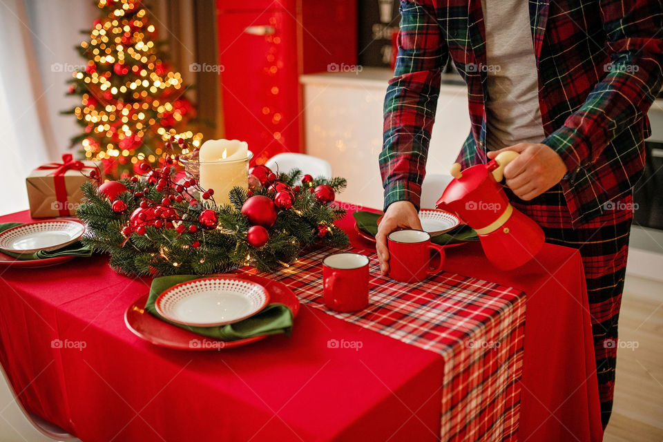 man sets a beautiful decorated winter table for a festive dinner.  Merry Christmas and Happy New Year.