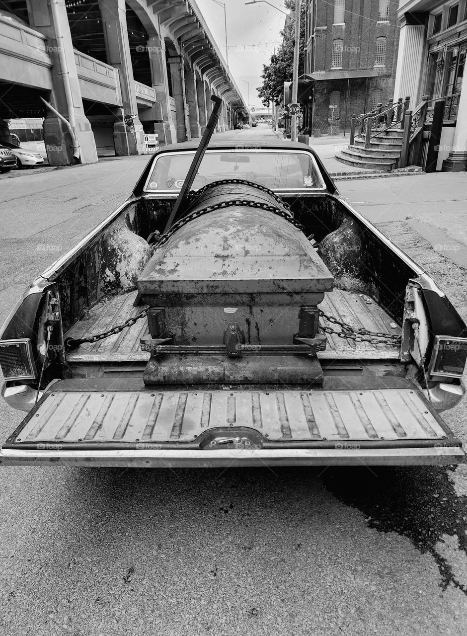 Death is present in the back of a 1970 Chevy El Camino as a casket is chained to the bed