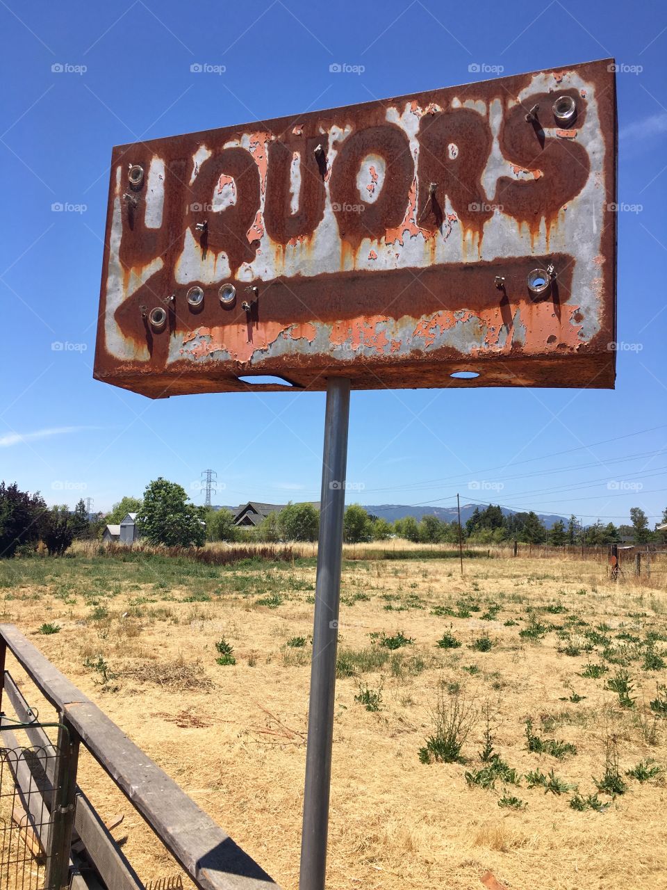 An old sign along a Sonoma county road directs one to liquors at a road side stop gone long ago. 