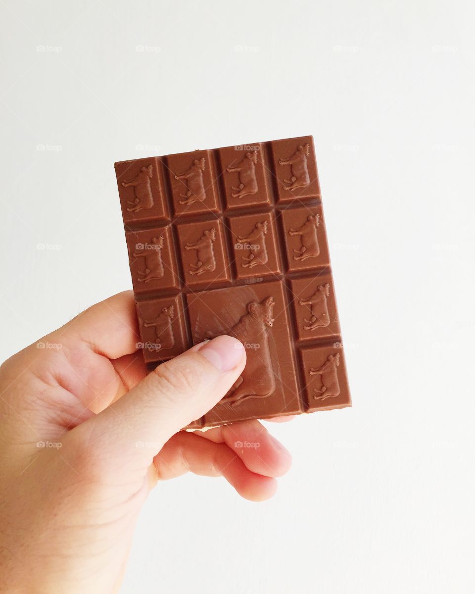 Person's hand holding chocolate bar sweets