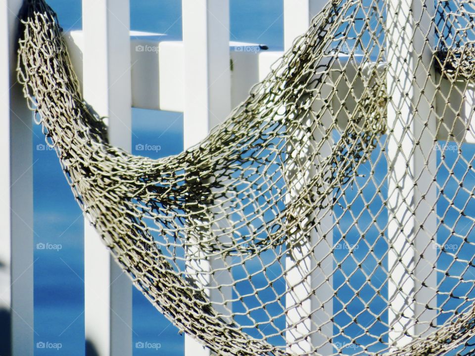 Fishing net on white fence