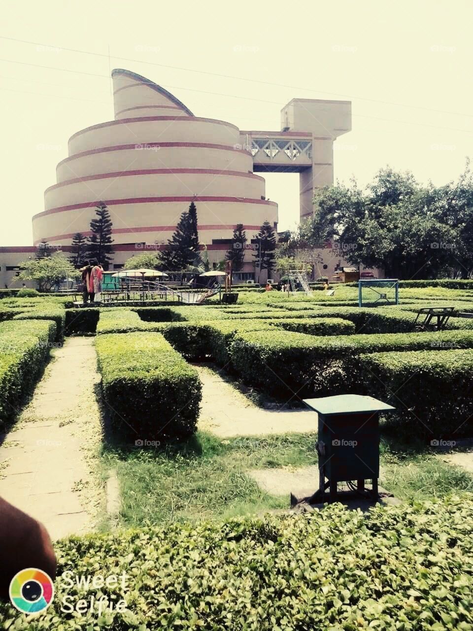 Round building and beautiful design by green flower plants in the garden