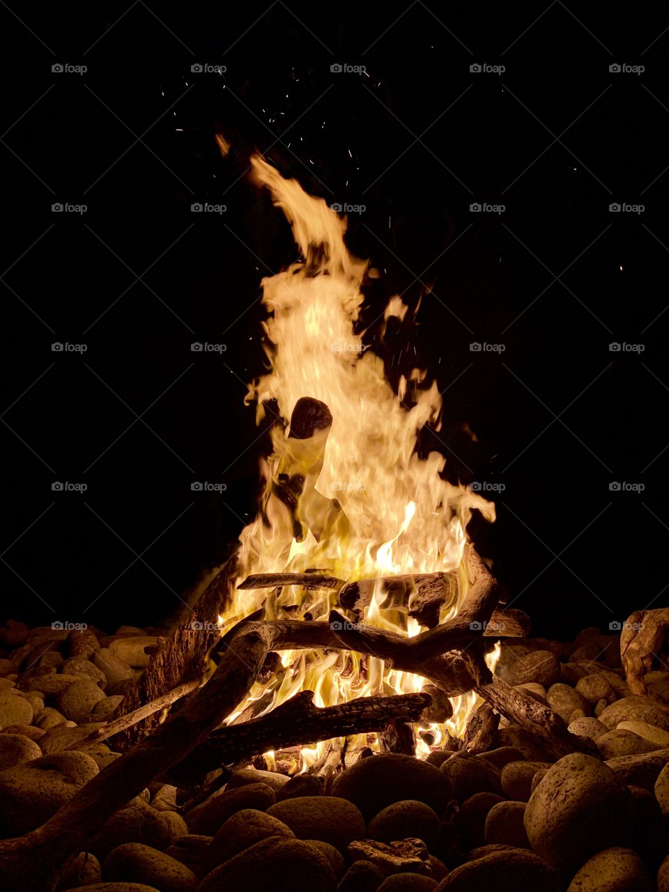 A blistering hot flame sizzling the energy out of the aged drift wood as the smooth stones gathered around explode in applause for it’s firey glory!