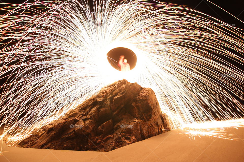 Firework display near rock at night