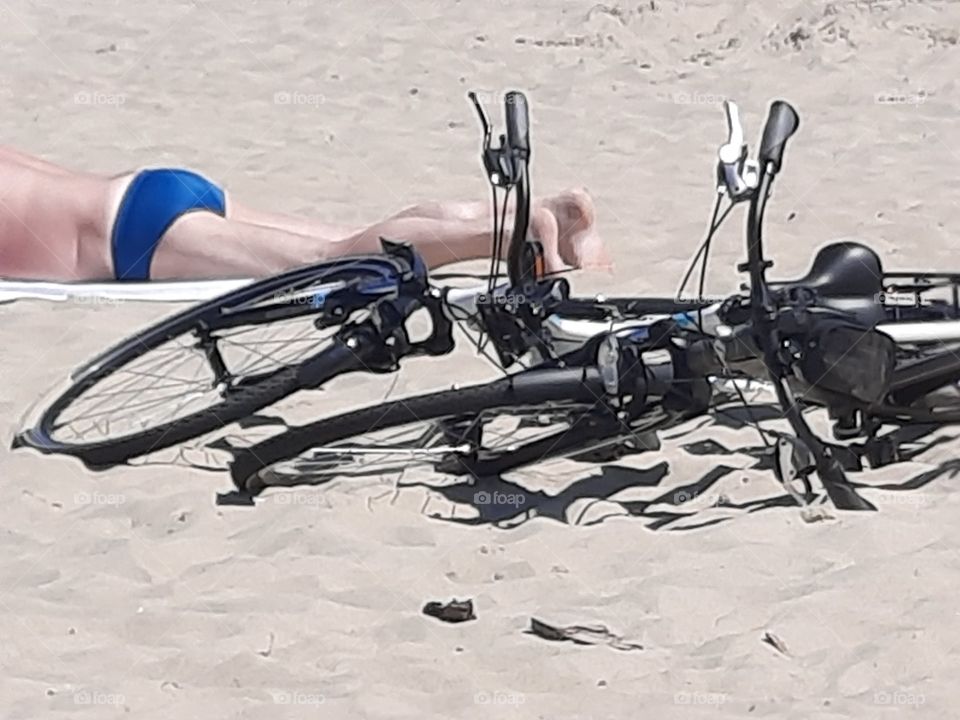 sunbathing on a  beach after bike ride