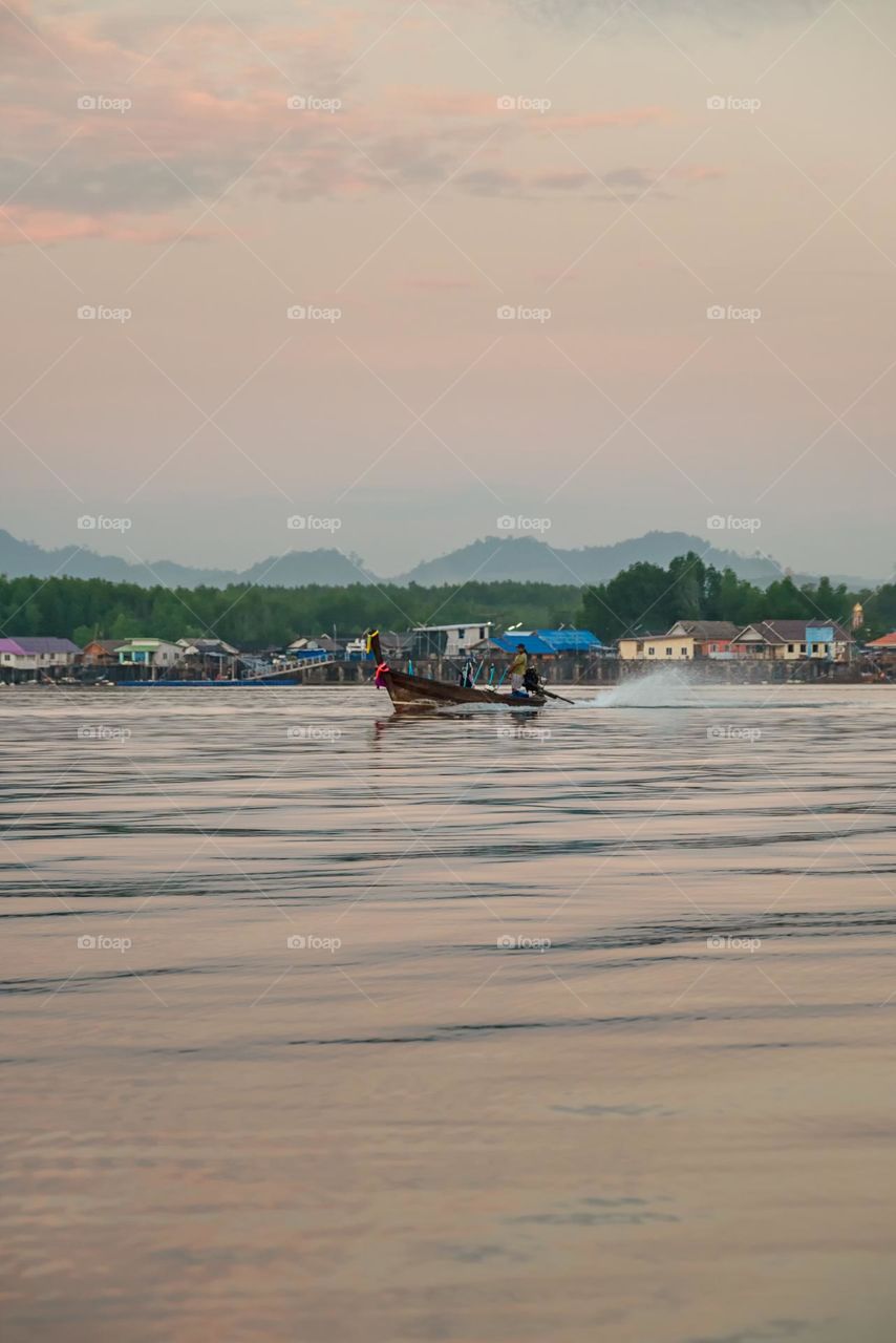 Beautiful Sunrise moment above silhouette of boat in sea