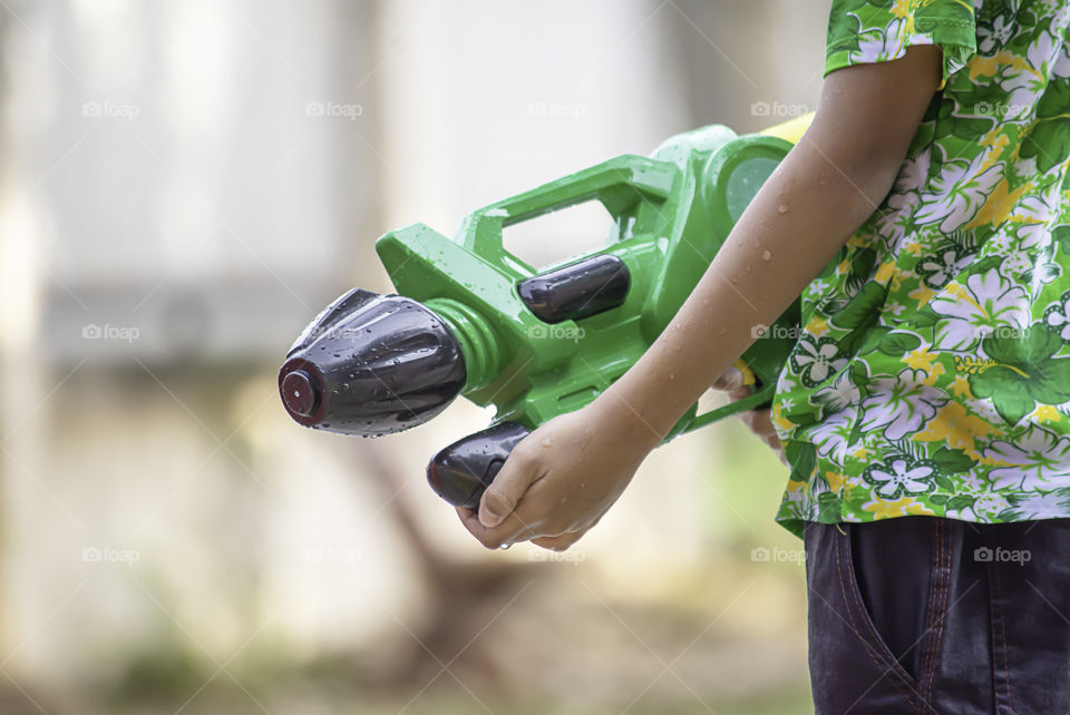 Hand holding a water gun play Songkran festival or Thai new year in Thailand.