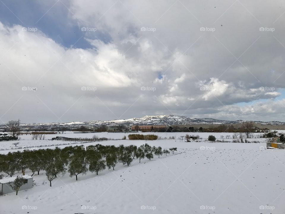 Cloudy sky upon village in snow, Italy, Abruzzo, Montepagano, snowy hilltop, snow 