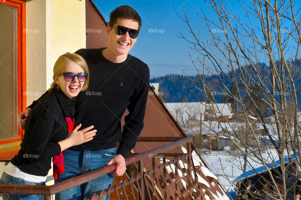 Smiling couple standing in balcony