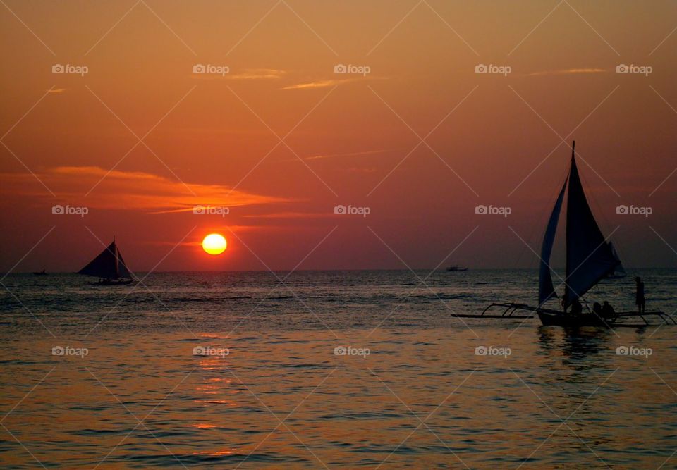 Silhouette of sailboat during sunset